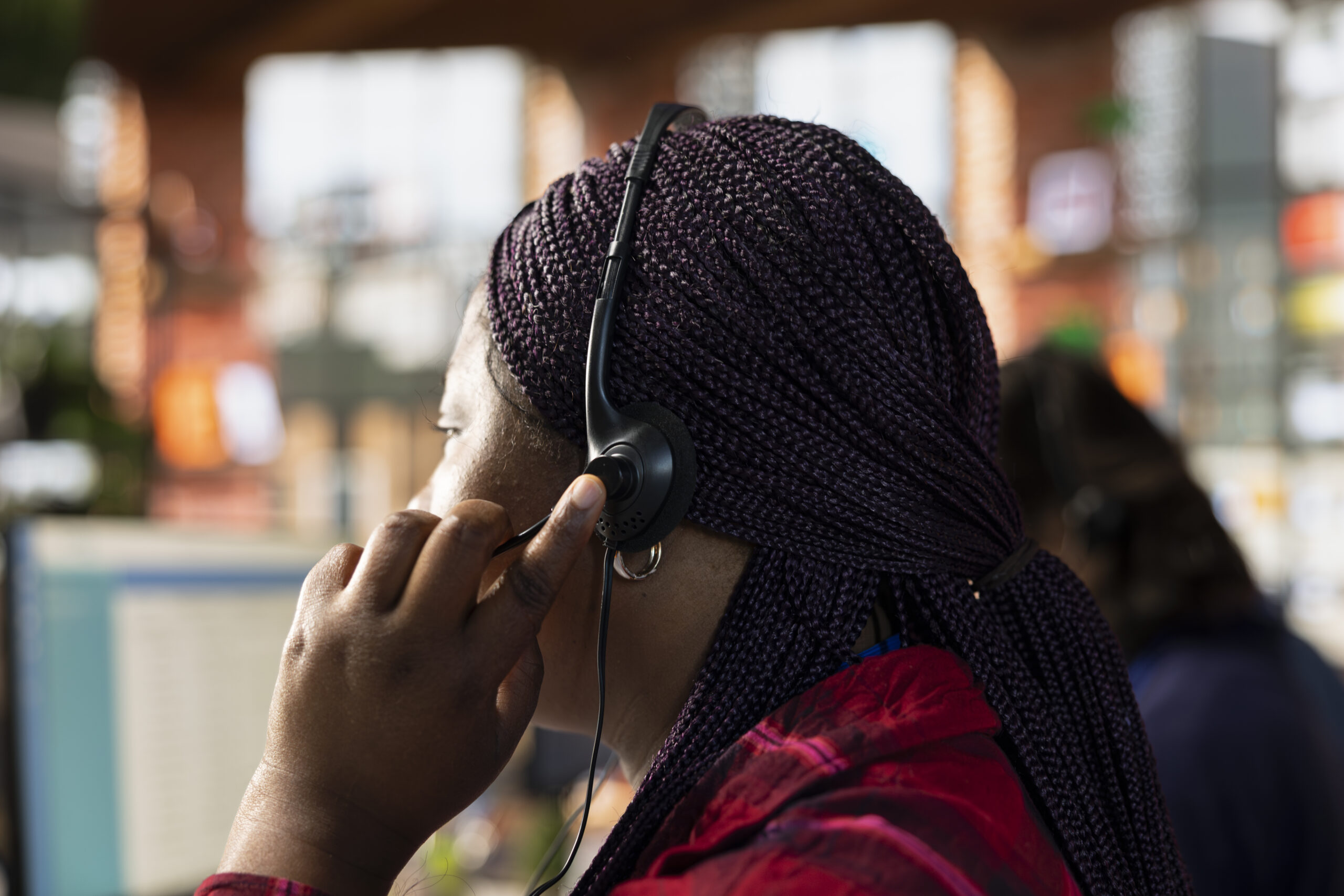 Home call center agent in office using headset mic to answer questions, close up