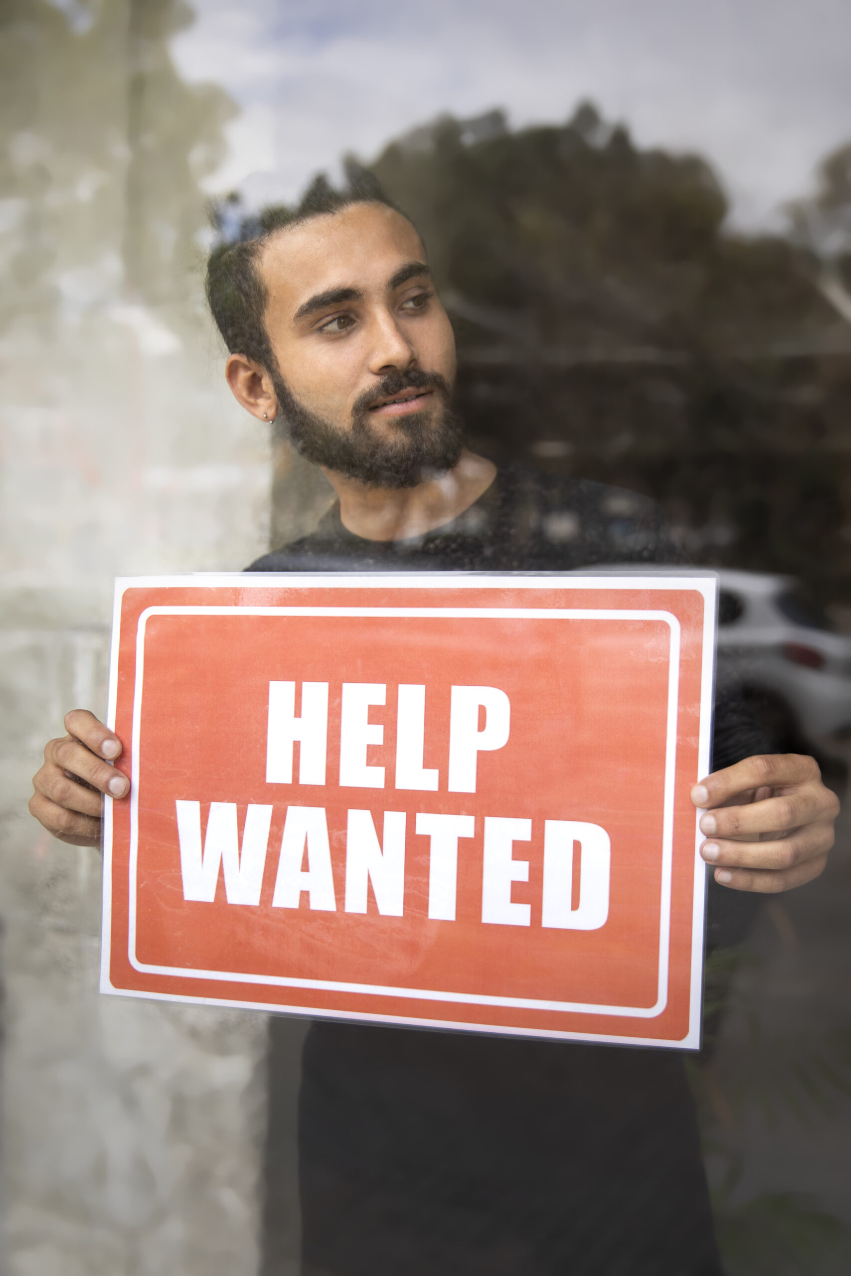 Home Person With Hiring Sign By Window Scaled