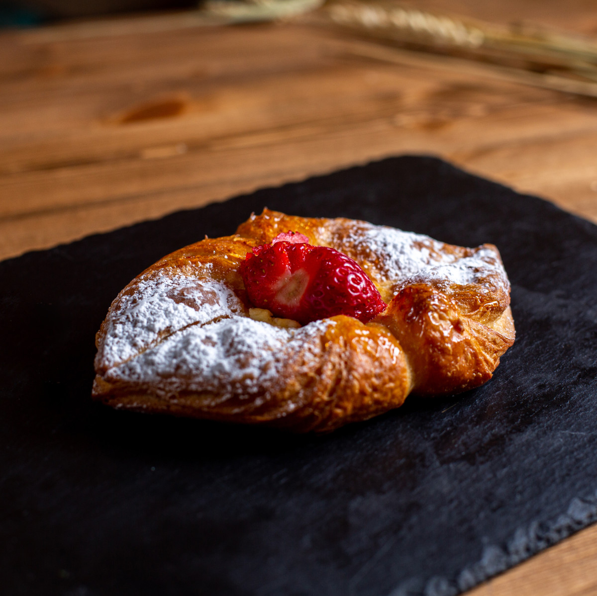 a front view sweet bagel with sugar powder on the black tissue y
